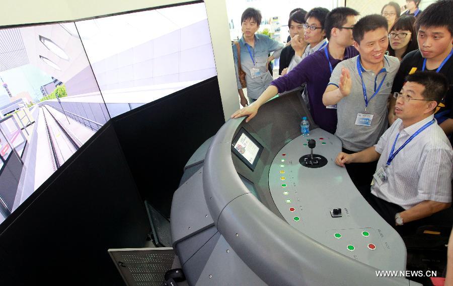 Visitors experience automatic control system of trains on the exhibition "Rail + Metro China 2013" in Shanghai, east China, June 4, 2013. The exhibition, showcasing metro and rail-related technologies and products worldwide, kicked off here Tuesday. (Xinhua/Pei Xin)