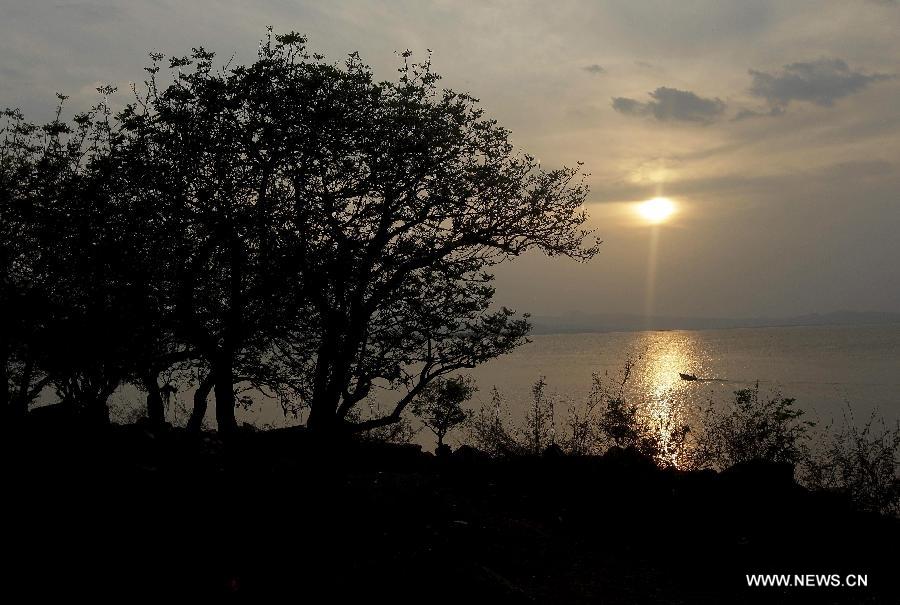 Image taken on May 12, 2013, shows the sun's reflection over lake Guija, in Santa Ana, El Salvador. Lake Guija, which possesses a total extension of 42 square kilometers and is located on the border between Guatemala and El Salvador, is visited by hundreds of national tourists every year. On every June 5, the "World Environment Day" is celebrated worldwide, which was established by the United Nations (UN) in order to create awareness and sensitize the public opinion in relation to environmental themes, according to local press. (Xinhua/Oscar Rivera) 