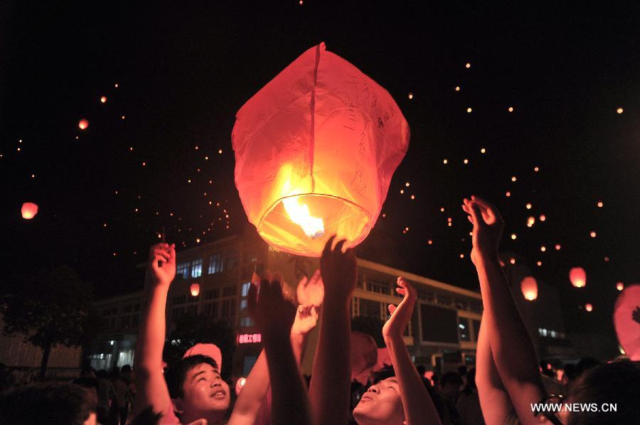 High school graduates fly a sky lantern, wishing for good luck in the coming national college entrance exams in Maotanchang Township of Lu'an City, east China's Anhui Province, June 4, 2013. High school graduates will take part in the national college entrance exams set for June 7-8. (Xinhua/Guo Chen)