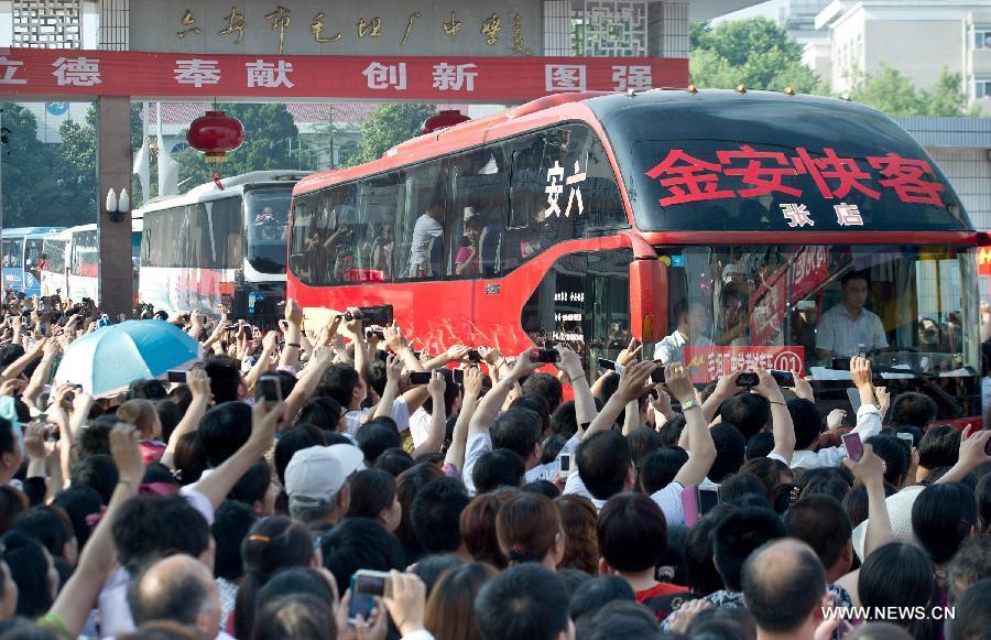 Coaches full of students leave the school, slowly moving in the crowd on Jun. 5, 2013. On this day, over 11,000 students from Maotanchang High School and Jin’an High School in Maotan town, Liu’an, Anhui province left for the university entrance exam places in Liu’an.(Photo/Xinhua)