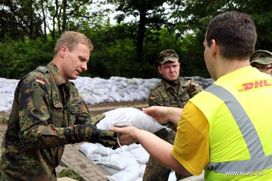 German Bundeswehr soldiers and local volunteers pass on sandbags to beef up the dike at Gimritzer Dammin in Halle, eastern Germany, on June 4, 2013. The water level of Saale River across Halle City is expected to rise up to its historical record of 7.8 meters in 400 years, due to persistent heavy rains in south and east Germany. (Xinhua/Pan Xu)  