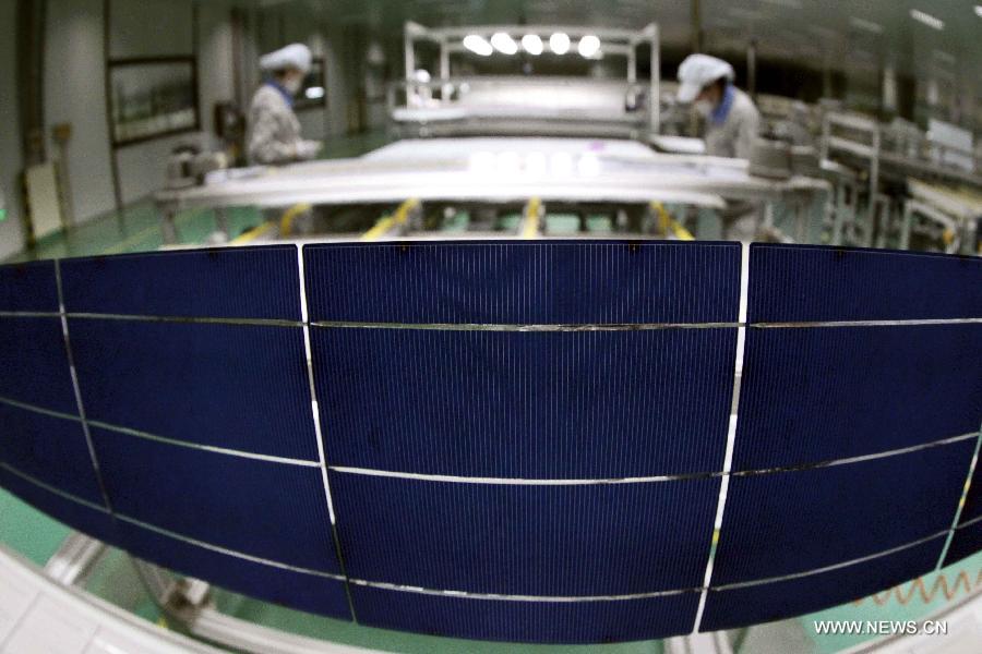 Workers make the solar photovoltaic products which will be exported to Europe at an energy company in Lianyungang City, east China's Jiangsu Province, June 4, 2013. On Tuesday, the European Commission announced its decision to introduce anti-dumping duties of 11.8 percent on solar panels imported from China. (Xinhua/Si Wei) 