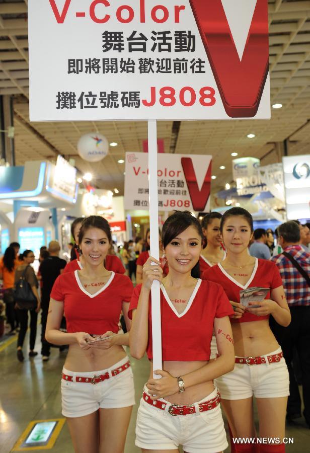 Employees raise advertisements for their pavilion at Computex Taipei 2013 exhibition, in Taipei, southeast China's Taiwan, June 4, 2013. The five-day exhibition opened here on Tuesday. (Xinhua/Tao Ming) 