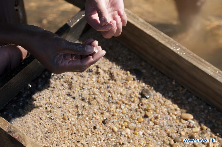 A local looks for sapphire in a river in Ilakaka town, the famous sapphire town in southwest Madagascar, on May 31, 2013. Since the discovery of alluvial sapphire deposits in 1998, the population had boomed from 40 residents to near 60,000 by 2005, including many businessmen from Thailand, India, France, China, etc., most of whom dreamed to become rich in one night to find sapphires. Madagsacar, famous for its sapphire production, stood alongside Australia as one of the world's two largest sapphire producers at its peak period. There are still sapphire mines operating around Ilakaka, but most deposits are located deeper below the surface now, and miners have to work much harder to extract sapphires. Due to the deep location and political crisis, Madagascar has not managed to regain its former glory as a primary producer of sapphires. (Xinhua/He Xianfeng)