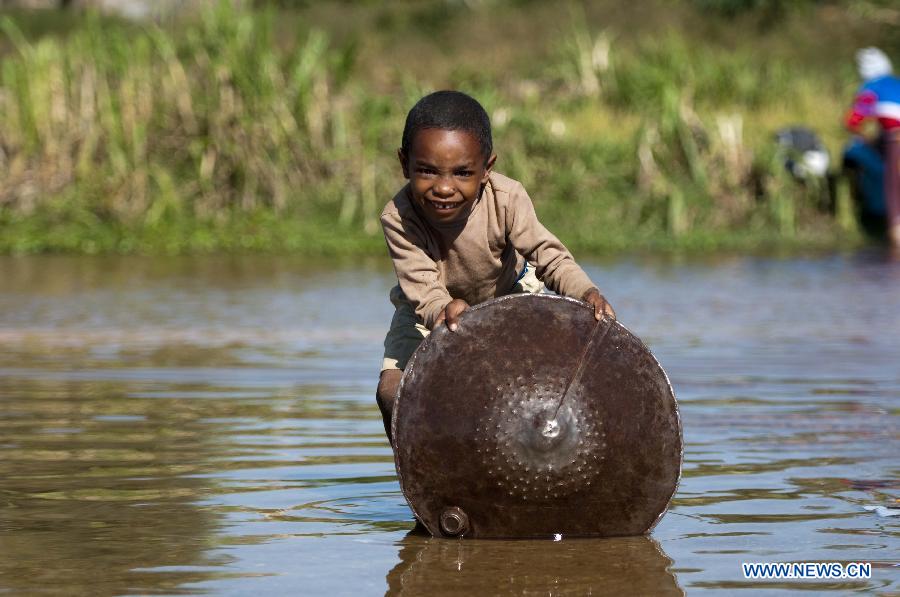 A child looks for sapphire in a river in Ilakaka town, the famous sapphire town in southwest Madagascar, on May 31, 2013. Since the discovery of alluvial sapphire deposits in 1998, the population had boomed from 40 residents to near 60,000 by 2005, including many businessmen from Thailand, India, France, China, etc., most of whom dreamed to become rich in one night to find sapphires. Madagsacar, famous for its sapphire production, stood alongside Australia as one of the world's two largest sapphire producers at its peak period. There are still sapphire mines operating around Ilakaka, but most deposits are located deeper below the surface now, and miners have to work much harder to extract sapphires. Due to the deep location and political crisis, Madagascar has not managed to regain its former glory as a primary producer of sapphires. (Xinhua/He Xianfeng)