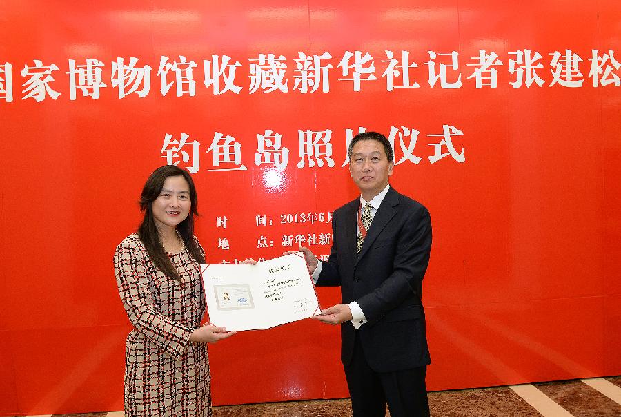 Chen Yu (R), on behalf of the National Museum of China, awards the certificate to Zhang Jiansong, a reporter for Xinhua News Agency, for acquiring Zhang's photos of Chinese surveillance ships patrolling the country's territorial waters surrounding the Diaoyu Islands, in Beijing, capital of China, June 5, 2013. The photos were taken by Zhang on Sept. 14 last year, when a fleet composed of surveillance ships 50, 15, 26, 27, 51 and 66 patrolled waters surrounding the Diaoyu Islands to demonstrate China's sovereignty over the islands and ensure the country's maritime interests. (Xinhua/He Junchang)