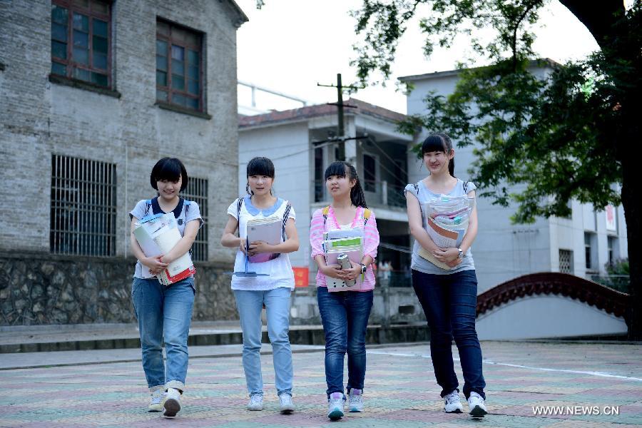 Students holding books head for their dormitory at the Jinzhai No. 1 Senior High School in Liuan, east China's Anhui Province, June 5, 2013. The annual national college entrance exam will take place on June 7 and 8. Some 9.12 million applicants are expected to sit this year's college entrance exam, down from 9.15 million in 2012, according to the Ministry of Education (MOE). (Xinhua/Zhang Duan)