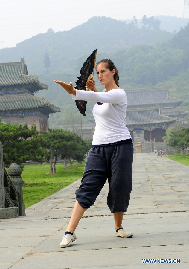 A foreign learner practises Chinese martial arts movements at the Yuxu Palace on Wudang Mountain, known as a traditional center for the teaching and practice of martial arts, in central China's Hubei Province, June 5, 2013. (Xinhua/Hao Tongqian) 