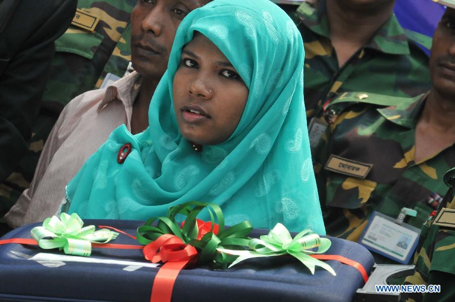 Reshma, a young female garment worker, receives a gift in Savar on the outskirts of Dhaka, Bangladesh, June 6, 2013. Miraculous Bangladeshi building collapse survivor Reshma will join Starwood Hotels and Resorts Worldwide, one of the top global hotel chains, as an ambassador, officials said Thursday. Eight-storey building Rana Plaza collapsed in Savar on the outskirts of the capital Dhaka on April 24, leaving at least 1,127 people dead. (Xinhua/Shariful Islam)