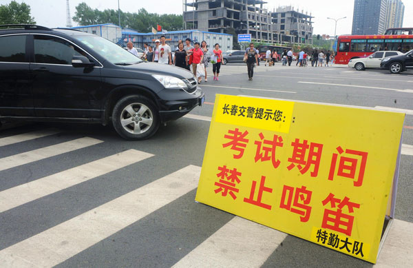 A sign reading, "No whistles during examination," is placed near a test site in Changchun, June 7, 2013. [Photo/Xinhua] 