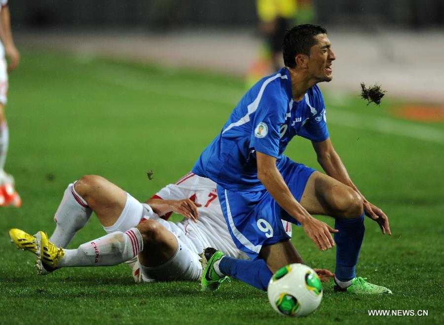 Odil Akhmedov (R) of Uzbekistan vies with Zhao Xuri of China during a friendly match in Hohhot, north China's Inner Mongolia Autonomous Region, June 6, 2013. Uzbekistan won the match 2-1. (Xinhua/Zhang Ling)