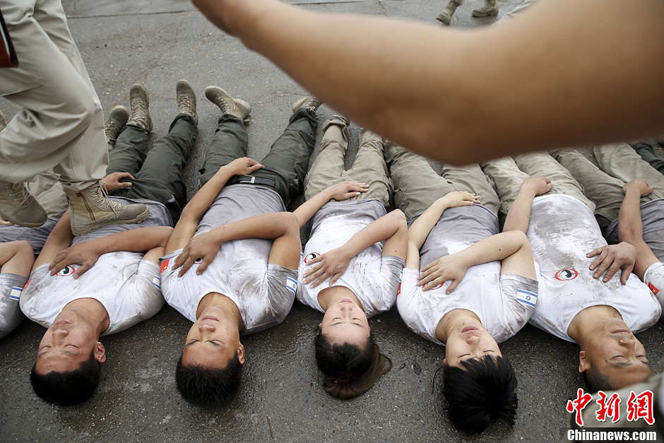 Trainees trample on fellow trainees during a VIP security training course at the Genghis Security Academy in Beijing, June 6, 2013. More than 70 trainees, including six women and three foreigners will receive high-intensity training for VIP security at a bodyguard camp in Beijing. They will train over 20 hours per day for one week. One third of the participants will be phased out at the end of the "Hell Week". (Photo/ Chinanews.com)