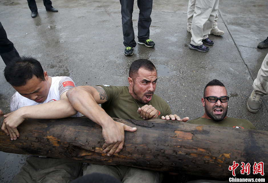 Trainees lift a log during a VIP security training course at the Genghis Security Academy in Beijing, June 6, 2013. More than 70 trainees, including six women and three foreigners will receive high-intensity training for VIP security at a bodyguard camp in Beijing. They will train over 20 hours per day for one week. One third of the participants will be phased out at the end of the "Hell Week".  (Photo/ Chinanews.com)