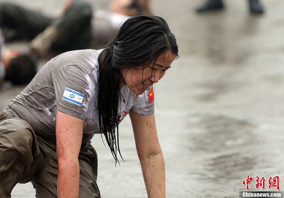 Trainees roll over the ground during a VIP security training course at the Genghis Security Academy in Beijing, June 6, 2013. More than 70 trainees, including six women and three foreigners will receive high-intensity training for VIP security at a bodyguard camp in Beijing. They will train over 20 hours per day for one week. One third of them will be eliminated. (Photo/ Chinanews.com)