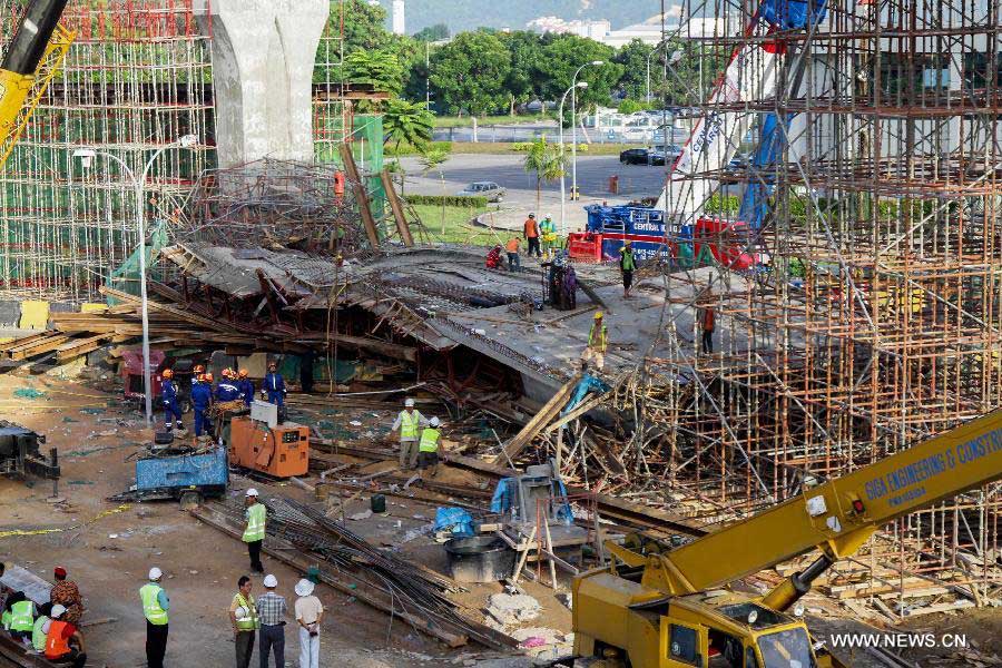 Workers of a rescue team work at the site of the collapsed bridge in the northeastern state of Penang, Malaysia, June 7, 2013. An interchange ramp to a cross-sea bridge that is under construction in northern Malaysia collapsed on Thursday, and rescue teams are still searching for survivors who might be trapped under the debris. (Xinhua) 