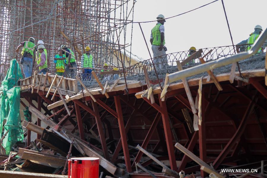 Workers of a rescue team work at the site of the collapsed bridge in the northeastern state of Penang, Malaysia, June 7, 2013. An interchange ramp to a cross-sea bridge that is under construction in northern Malaysia collapsed on Thursday, and rescue teams are still searching for survivors who might be trapped under the debris. (Xinhua) 