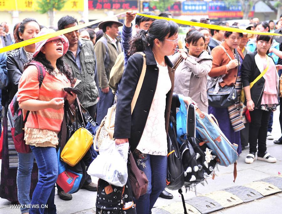 Teachers help carry bags for examinees of the national college entrance exam outside the exam sites at the Lhasa Middle School in Lhasa, capital of southwest China's Tibet Autonomous Region, June 7, 2013. Some 9.12 million applicants are expected to sit this year's college entrance exam on June 7 and 8. (Xinhua/Liu Kun)