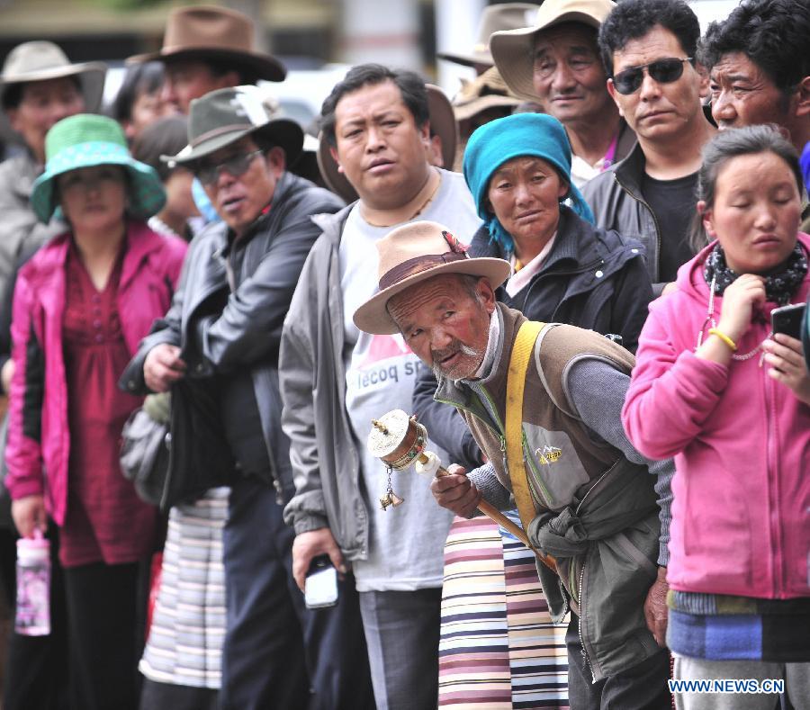 Family members of examinees of the national college entrance exam wait outside the exam site at the Lhasa Middle School in Lhasa, capital of southwest China's Tibet Autonomous Region, June 7, 2013. Some 9.12 million applicants are expected to sit this year's college entrance exam on June 7 and 8. (Xinhua/Liu Kun)