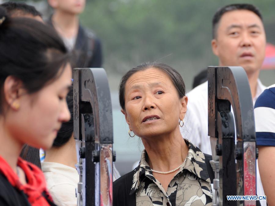 A mother waits for her kid taking the national college entrance exam in Gu'an, north China's Hebei Province, June 7, 2013. Some 9.12 million applicants are expected to sit this year's college entrance exam. (Xinhua/Wang Xiao) 