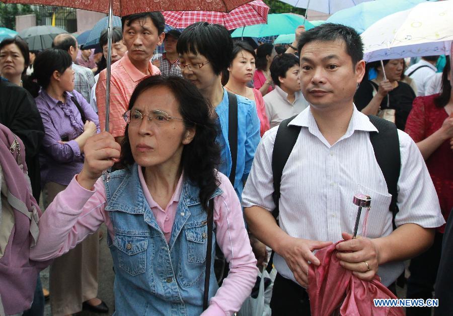 Parents watch their children entering the exam site to take the national college entrance exam in Shanghai, east China, June 7, 2013. Some 9.12 million applicants are expected to sit this year's college entrance exam. (Xinhua/Pei Xin)