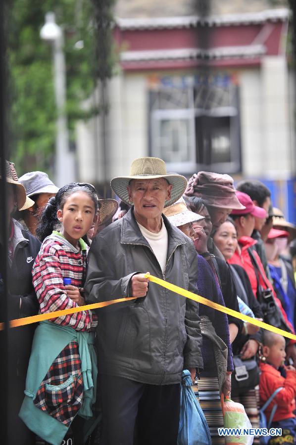 Family members of examinees of the national college entrance exam wait outside the exam site at the Lhasa Middle School in Lhasa, capital of southwest China's Tibet Autonomous Region, June 7, 2013. Some 9.12 million applicants are expected to sit this year's college entrance exam on June 7 and 8. (Xinhua/Liu Kun)