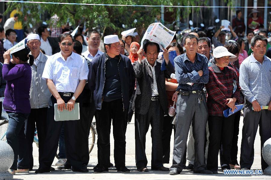 Family members of examinees of the national college entrance exam wait outside the exam site at the Xiji Middle School in Xiji County, northwest China's Ningxia Hui Autonomous Region, June 7, 2013. Some 9.12 million applicants are expected to sit this year's college entrance exam on June 7 and 8. (Xinhua/Peng Zhaozhi)