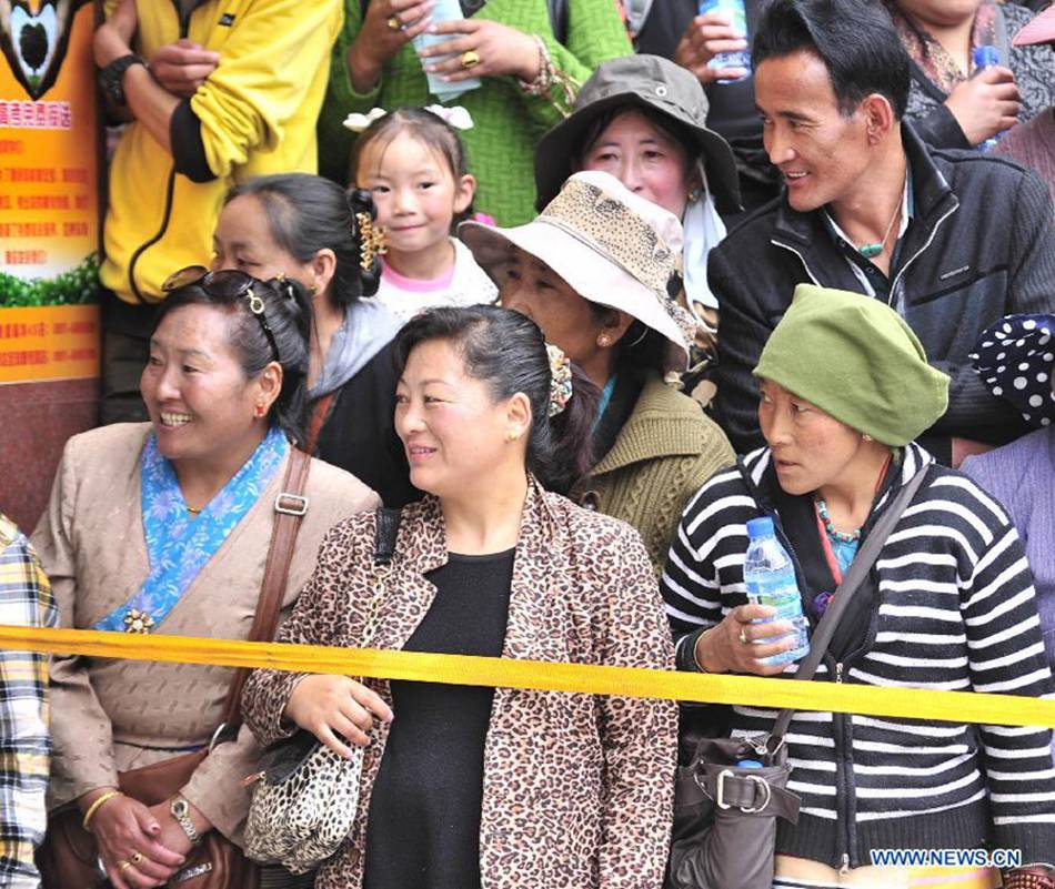 Parents wait outside the exam site as their children taking the national college entrance exam at the Lhasa Middle School in Lhasa, capital of southwest China's Tibet Autonomous Region, June 7, 2013. Some 9.12 million applicants are expected to sit this year's college entrance exam on June 7 and 8.