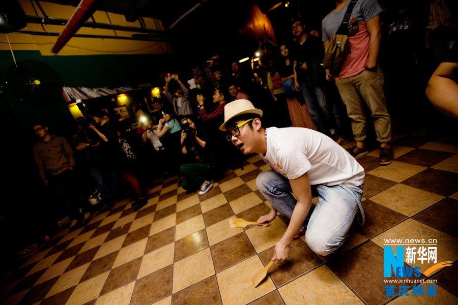 Huang Yigua uses a cooking spoon to play music. (Photo/Xinhua)