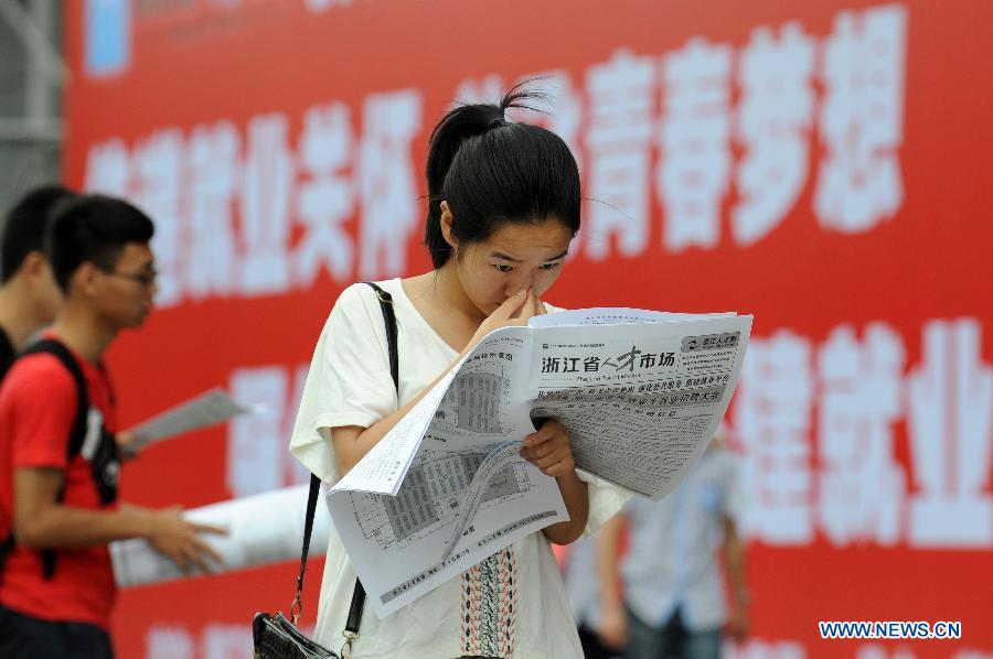 A student checks job information at a job fair in Hangzhou, capital of east China's Zhejiang Province, June 8, 2013. The job fair offered over 25,000 job posts to college graduates. (Xinhua/Ju Huanzong)
