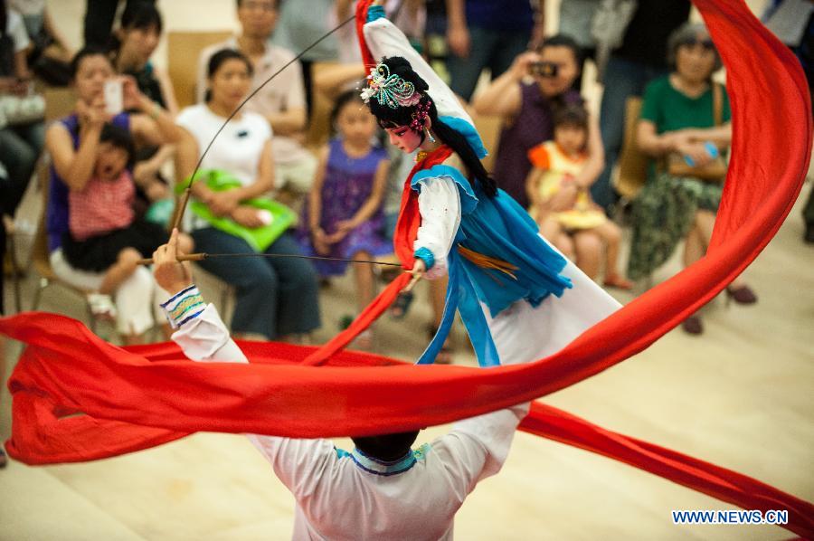 A performer operates a puppet during a Lingnan puppet show held by the Guangdong Provincial Puppet Art Theater at the Guangzhou Library to mark the 8th national Cultural Heritage Day in Guangzhou, capital of south China's Guangdong Province, June 8, 2013. (Xinhua/Mao Siqian)