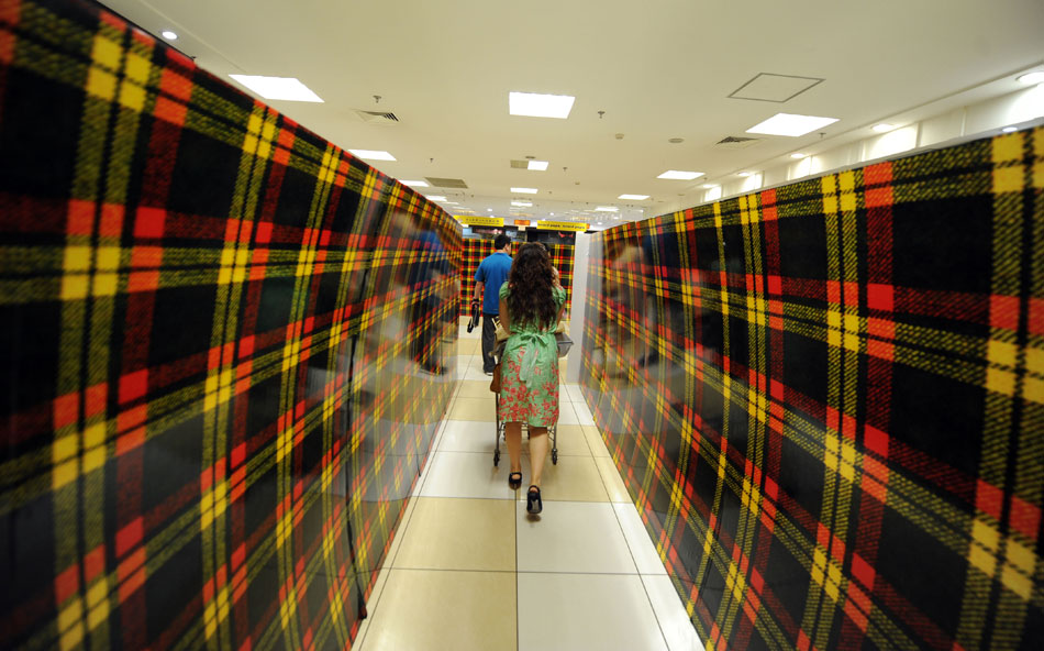 People walk in the Isetan shopping mall in Shenyang on May 31, 2013. Most of the shelves in the mall had been closed up. Isetan, Japan's shopping mall giant, announced on June 1 the closure of the mall in Shenyang which was openned five years ago. It was the third mall that it has closed in China. (Xinhua/Yao Jianfeng)