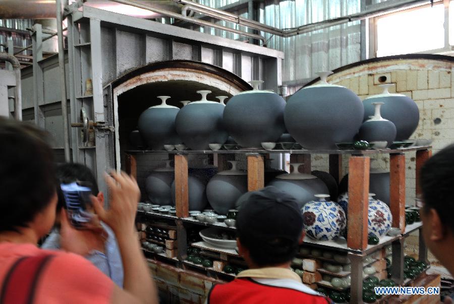 Tourists visit a kiln workshop in the town of Yingge of Xinbei City in southeast China's Taiwan, June 8, 2013. Over 100 artists have set up workshops in Yingge, which is famous for ceramics production, providing opportunities for visitors to experience the process of making porcelains. (Xinhua/Tao Ming) 