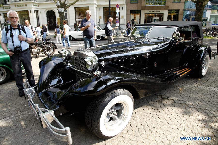 A visitor appreciates a classic old-timer car during a grand exhibition of the classic vintage cars, on the Kurfuerstendamm Avenue, in Berlin, Germany, June 8, 2013. Some 2,000 well-preserved and well-functioning classic vintage cars and limousines at least over 50-year-old are exhibited at the fair, with the motto "when luxury meets classics". (Xinhua/Pan Xu) 