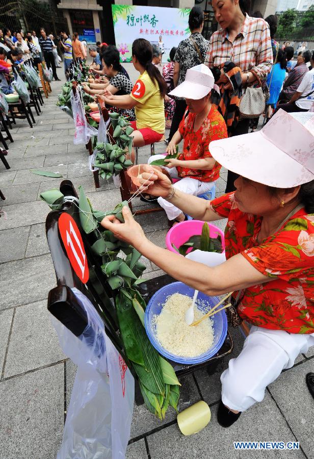 Contestants make Zongzi, a pyramid-shaped dumpling made of glutinous rice wrapped in bamboo or reed leaves, during a contest in celebration of the upcoming Dragon Boat Festival in Changsha, capital of central China's Hunan Province, June 9, 2013. The Dragon Boat Festival falls on the fifth day on the fifth month on the lunar calendar. (Xinhua/Long Hongtao)