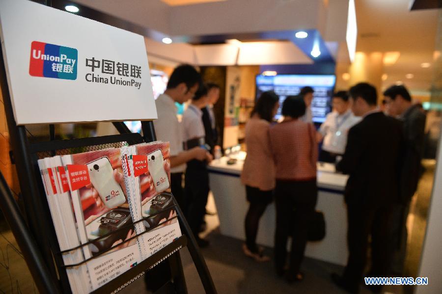 People consult information about the mobile payment platform in Beijing, capital of China, June 9, 2013. China's UnionPay bank card network established the mobile payment platform with telecom operator China Mobile, according to a press conference on Sunday. (Xinhua/Li Xin)