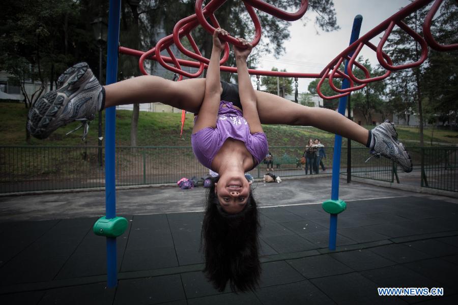 A woman practises pole dance on the Pole Dance National Day at a park in Mexico City, capital of Mexico, June 9, 2013. Mexican women gathered in parks around the country to practise pole dance June 9, the third Pole Dance National Day, or the Urban Pole National Day. The pole dance, practised as a sports event, has become popular among Mexican women. (Xinhua/Pedro Mera)