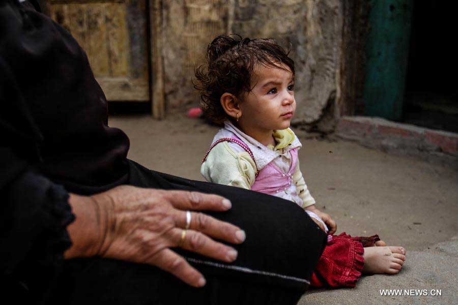 A Palestinian child sits on the ground in Fadel Island refugee camp in Sharqia, 90km northeast of Cairo, Egypt, June 10, 2013. Fadel Island village is a forgotten Palestinian refugee camp in Egypt, with about 4,000 Palestinian refugees who came to Eygpt since 1948 living in it. Refugees there are living in very harsh circumstances as the camp lacks of infrastructure, health care, education and jobs. As United Nations Relief and Works Agency for Palestine Refugees in the Near East (UNRWA) does not porvide direct service in Egypt, Egyptian government is alone responsible for these refugees. (Xinhua/Amru Salahuddien) 