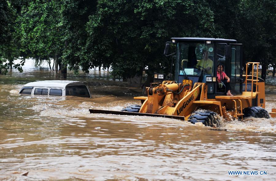 A forklift truck cleans the sludge in a flooded street in Liuzhou City, south China's Guangxi Zhuang Autonomous Region, June 11, 2013. Liujiang River's water level surpassed the warning line in urban Liuzhou on Monday, and started to descend in the night after the flood peak. (Xinhua/Li Bin) 