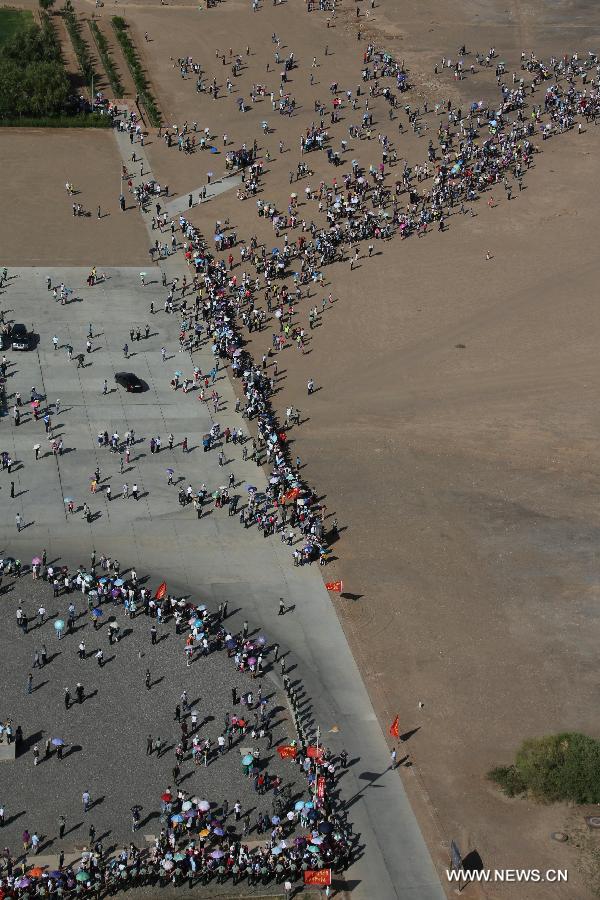 People wait to watch the launch of the manned Shenzhou-10 spacecraft at the Jiuquan Satellite Launch Center in Jiuquan, northwest China's Gansu Province, June 11, 2013. (Xinhua/Wang Jianmin)