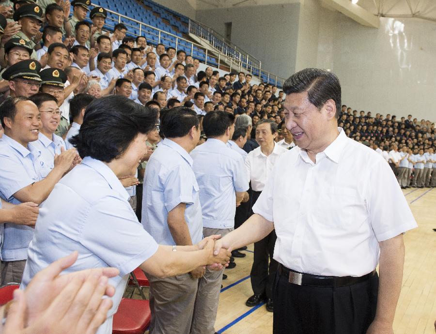 Chinese President Xi Jinping(R), also general secretary of the Central Committee of the Communist Party of China (CPC) and chairman of the Central Military Commission (CMC), shakes hands with those participating in the program of Shenzhou-10 manned spacecraft and sending his warm greetings to them at the Jiuquan Satellite Launch Center in Jiuquan, northwest China's Gansu Province, June 11, 2013. Xi watched conditions of the spacecraft through images and parameters on the screen at the command hall. (Xinhua/Li Xueren)