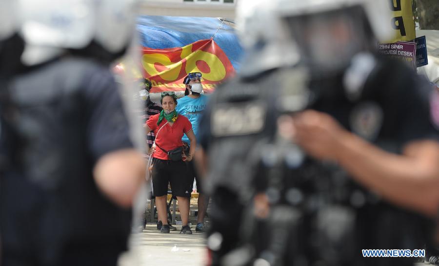 Demonstrators confront with police in the Taksim Square in Istanbul, Turkey, on June 11, 2013. Turkish riot police fired water cannon and teargas at hundreds of protesters in Istanbul's Taksim Square on Tuesday, entering the square for removing the roadblocks and cleanning up flags and banners. Demonstrators fought back with stones and fireworks. (Xinhua/Lu Zhe)