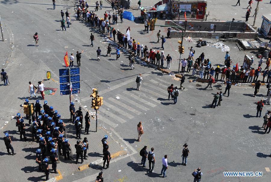 Demonstrators confront with police in the Taksim Square in Istanbul, Turkey, on June 11, 2013. Turkish riot police fired water cannon and teargas at hundreds of protesters in Istanbul's Taksim Square on Tuesday, entering the square for removing the roadblocks and cleanning up flags and banners. Demonstrators fought back with stones and fireworks. (Xinhua/Lu Zhe)