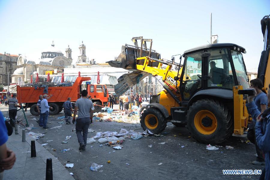 Police remove roadblocks in the Taksim Square in Istanbul, Turkey, on June 11, 2013. Turkish riot police fired water cannon and teargas at hundreds of protesters in Istanbul's Taksim Square on Tuesday, entering the square for removing the roadblocks and cleanning up flags and banners. Demonstrators fought back with stones and fireworks. (Xinhua/Lu Zhe)