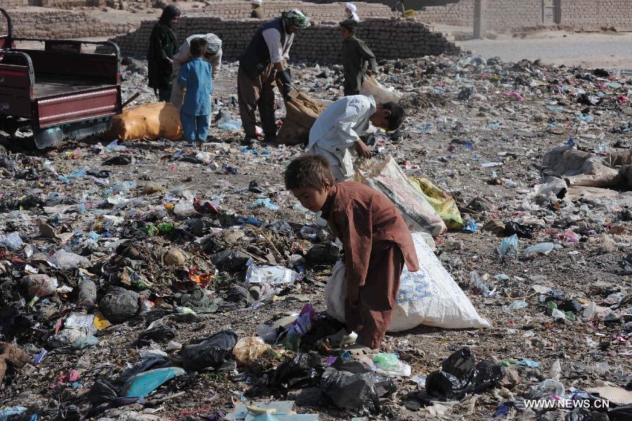 Afghan children collect empty bottles and plastic from a garbage site in Herat province in western of Afghanistan, on June 12, 2013. Afghan labor children work as usual on June 12 while many countries around the world mark the day as the World Day Against Child Labor. The International Labor Organization (ILO) mark the World Day Against Child Labor since 2002. (Xinhua/Sardar)