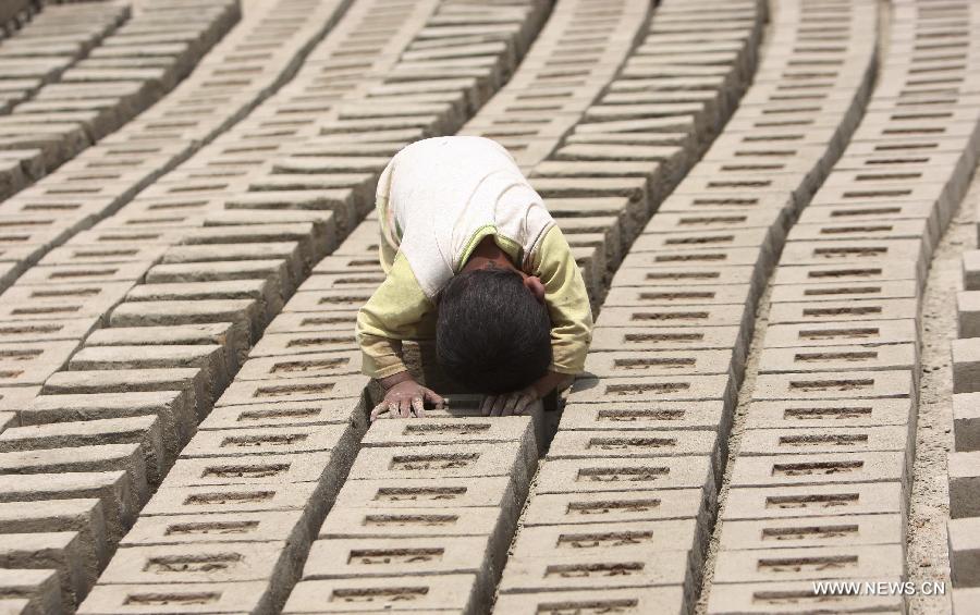 An Afghan child works at a brick factory in Kabul, Afghanistan on June 12, 2013. Afghan labor children work as usual on June 12 while many countries around the world mark the day as the World Day Against Child Labor. The International Labor Organization (ILO) launched the World Day Against Child Labor in 2002, which falls on each June 12. (Xinhua/Ahmad Massoud) 