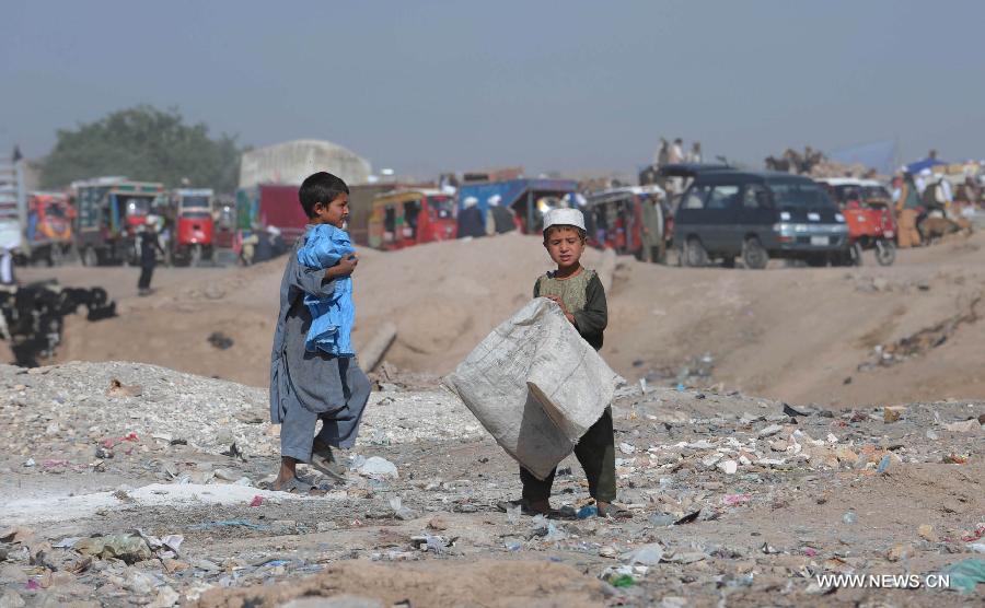 Afghan children collect empty bottles and plastic from a garbage site in Herat province in western of Afghanistan, on June 12, 2013. Afghan labor children work as usual on June 12 while many countries around the world mark the day as the World Day Against Child Labor. The International Labor Organization (ILO) mark the World Day Against Child Labor since 2002. (Xinhua/Sardar)