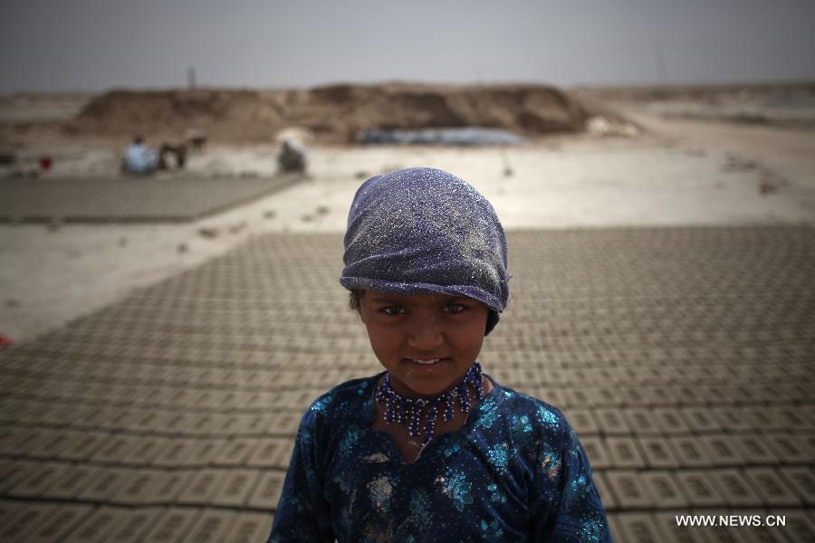 An Afghan girl stands at a brick factory in Kabul, Afghanistan on June 12, 2013. Afghan labor children work as usual on June 12 while many countries around the world mark the day as the World Day Against Child Labor. The International Labor Organization (ILO) launched the World Day Against Child Labor in 2002, which falls on each June 12. (Xinhua/Ahmad Massoud) 