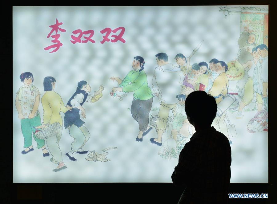 A visitor views a picture at an exhibition showcasing serial pictures created by He Youzhi on love stories at the Zhejiang Art Museum in Hangzhou, east China's Zhejiang Province, June 12, 2013. The exhibition kicked off here Wednesday, where the serial picture master displayed his works created since 1949. (Xinhua/Shi Jianxue)