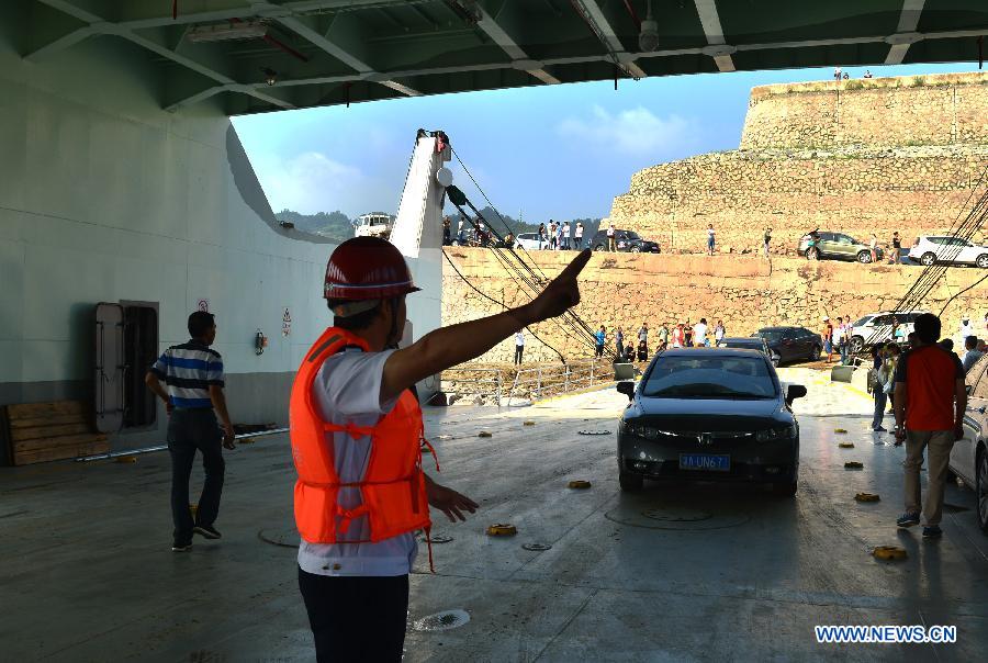 Cars board the "Zhongbaodao" ro-ro cruise ship under the instruction of staff members at Yinxiangtuo wharf in Zigui County, central China's Hubei Province, June 11, 2013. "Zhongbaodao" ro-ro cruise ship, the first one of this kind in Three Gorges reservoir region, was officially put into service on Tuesday. (Xinhua/Zheng Jiayu) 