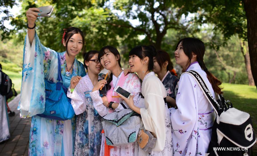 Girls wearing the archaic costumes typical of the Han Dynasty (202 BC - 221 AD) pose for a photo during an event to commemorate Quyuan, a famous ancient official who drowned himself for finding no way to make his small hinterland kingdom better, and spend the holiday of Dragon Boat Festival in Beijing, China, June 12, 2013. (Xinhua/Wang Jianhua) 